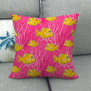 Detail of linen pillowcase with yellow tropical fish and pink coral print on sofa