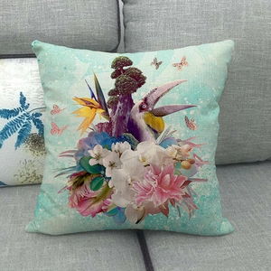 Close-up of tropical floral linen cushion with toucan and orchid patterns on a sofa