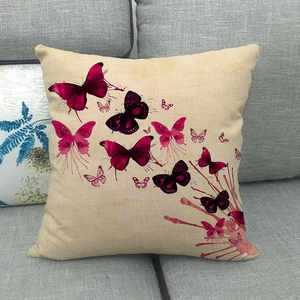 Close-up of linen pillow cover featuring pink and purple butterflies on a grey sofa