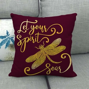 Detail of burgundy linen pillow with gold Let your Spirit Soar text and dragonfly print