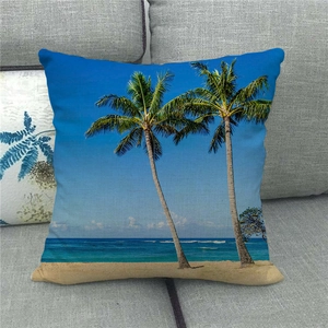 Detail of tropical palm tree watercolor print on linen pillowcase over a grey sofa