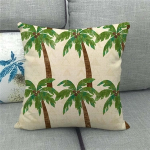 Close-up of tropical palm tree pattern on a linen throw pillowcase on a grey sofa