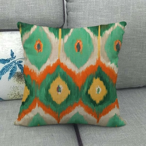 Abstract geometric ikat cushion cover in green and orange on textured linen fabric