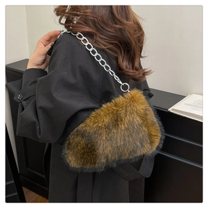 Detail of plush faux fur shoulder bag with chunky silver metal chain strap in dark brown