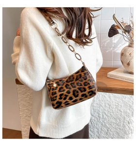 Detail of leopard print glossy shoulder bag with amber resin chain and sleek PU leather
