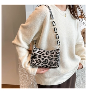 Detail of leopard print underarm bag featuring glossy finish and four-stitch logo design