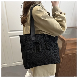 Detail of vintage leopard print tote bag featuring decorative drawstrings and side pockets