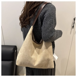 Detail of soft apricot suede tote bag with contrast brown leather shoulder strap
