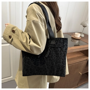 Leopard print tote bag with thick rope details shown on a shoulder in a home setting
