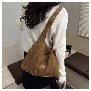 Brown suede tote bag detail featuring the wide shoulder strap and soft velvet texture