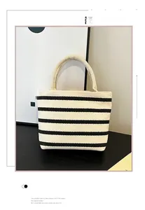 Detail of striped canvas tote bag showing thick cylindrical handles and black white pattern