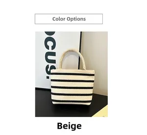 Detail view of the beige canvas tote bag with black horizontal stripes and woven handles