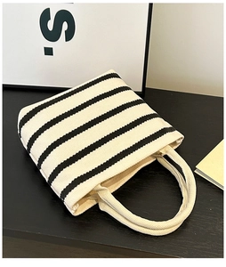 Close-up of minimalist black and white striped canvas tote bag with dual handles