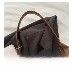 Detail view of brown leather handle and three-color bead charm on vintage tote bag