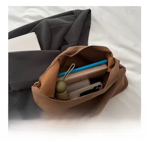 Spacious brown tote bag showing interior storage for a tablet, notebook, and umbrella
