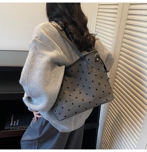 Detail shot of grey fabric tote bag with black polka dots and leather straps for women