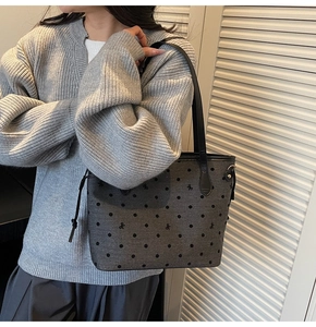 Detailed view of grey fabric tote bag featuring black polka dots and small bow patterns