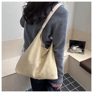 Detail of soft beige tote bag with a suede texture shown on shoulder for daily commute