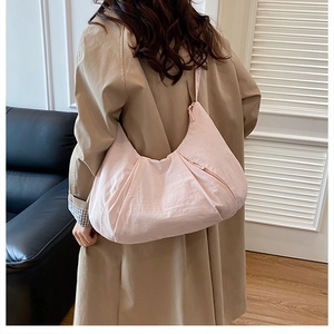 Pale pink large hobo bag worn by model, showing spacious casual design for daily commute