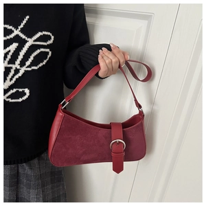 Détail du sac baguette bordeaux avec panneau en daim et boucle argentée décorative