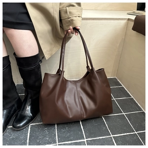 Braune Shopper-Tasche aus Kunstleder getragen von Model für den täglichen Look