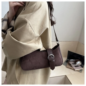 Détail du sac sous l'aisselle en daim marron foncé avec boucle argentée