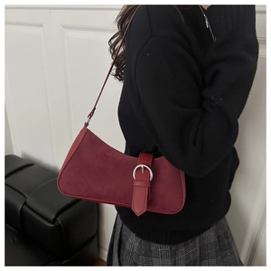 Gros plan du sac sous le bras rétro bordeaux avec empiècements en daim et boucle argent