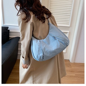 Light blue pleated nylon tote bag shown on model for size and capacity detail