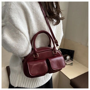 Détail du sac fourre-tout bordeaux en similicuir avec poches à rabat et logo mode