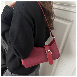 Détail du sac sous l'aisselle vintage rouge foncé avec texture daim sur modèle