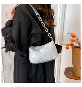 Detail of silver metallic hobo bag with pleated texture and white acrylic chain strap