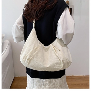 Detail of off-white oversized crescent crossbody bag featuring textured pleated nylon fabric