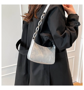 Detail of silver metallic hobo bag with large white ring chain strap on a model
