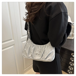 Silver pleated hobo bag with metal butterfly logo shown being worn by a model