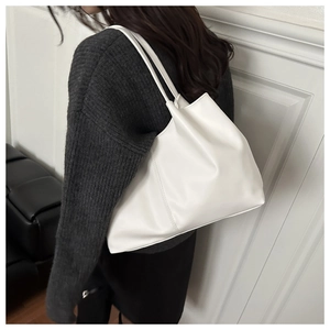 Detail of a white minimalist tote bag showing premium PU leather texture and fine stitching