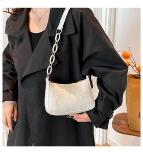 Detail of off-white corduroy underarm bag with acrylic chain strap and zip closure