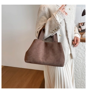 Brown suede tote bag shown on person, highlighting the matte texture and casual style