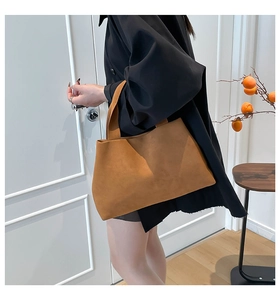 Minimalist caramel suede tote bag shown in a warm indoor lifestyle setting with models