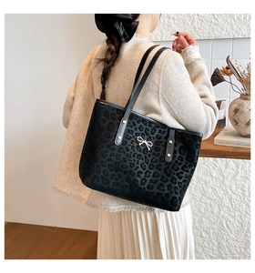 Close-up of leopard print tote bag with silver bow detail and sturdy shoulder straps