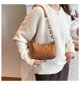 Detail of bronze brown textured shoulder bag with striped finish and chain strap