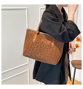 Close-up of leopard print tote bag with gold bow buckle and slim shoulder straps