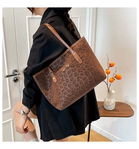 Side view of leopard print tote bag with gold bow detail on a female model