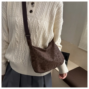 Leopard print crossbody crescent bag shown with a model for style and size reference