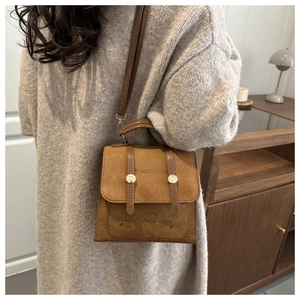 Close-up of brown vintage crossbody bag with cute animal patterns and gold metal buckle