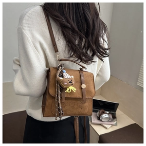 Brown matte retro mini backpack with teddy bear charm and STUDIO text detail