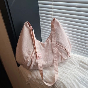 Light pink crescent nylon tote bag with adjustable strap for daily commute use
