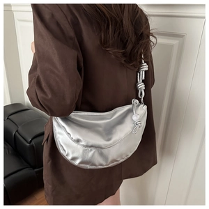 Détail du sac demi-lune argenté métallisé avec bandoulière nouée et sphère décorative