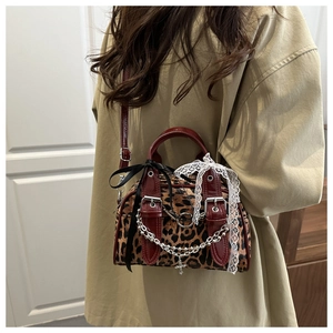 Leopard print crossbody bag detail with silver chains and a dark red leather strap
