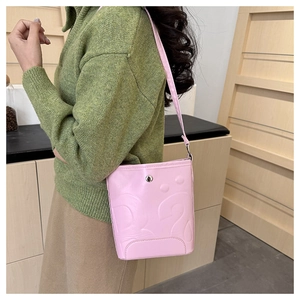 Détail du sac seau rose avec texture gaufrée et fermeture magnétique en métal