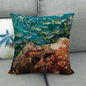Linen cushion cover featuring a realistic marine iguana and school of fish on a sofa